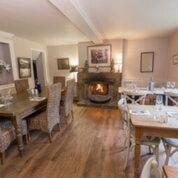 a dining room with tables and a fireplace in a room at The Crown Inn in Towcester
