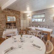 a dining room with white tables and chairs at The Crown Inn in Towcester
