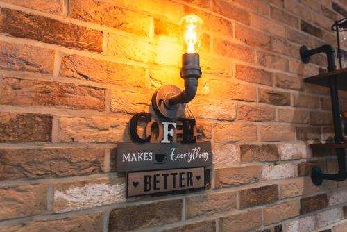 a light on a brick wall with a sign on it at Manor House Apartment in Bournemouth