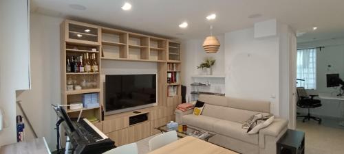 un salon avec un canapé et une télévision à écran plat dans l'établissement Calm & Charming Atelier in Paris, à Paris