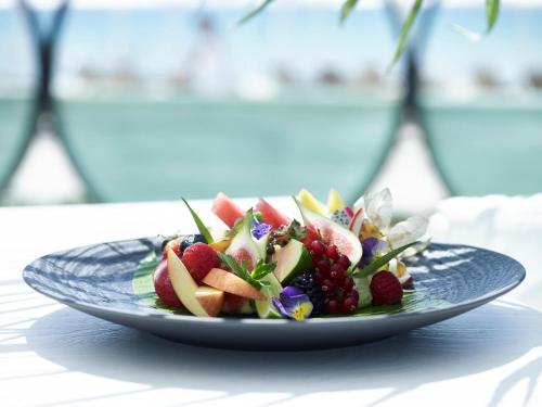 a plate of fruit salad on a table at Porto Sani in Sani Beach