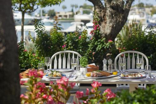 a table with plates of food and wine glasses at Porto Sani in Sani Beach