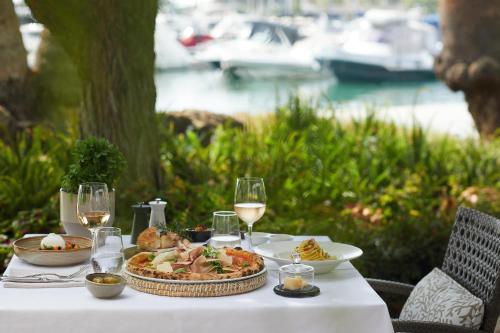 a table with a plate of food and glasses of wine at Porto Sani in Sani Beach
