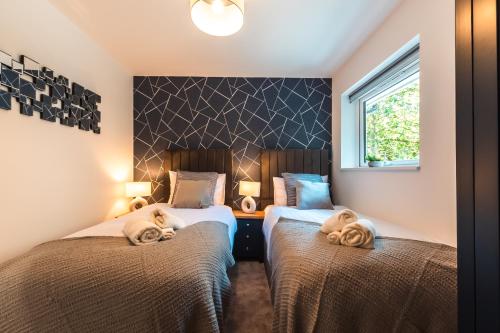 a bedroom with two beds with towels on them at Manor House Apartment in Bournemouth
