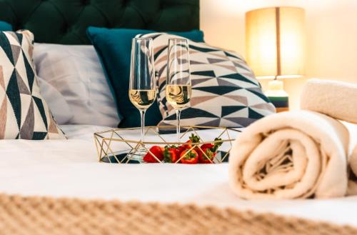 a bed with two glasses of champagne and a tray of strawberries at Manor House Apartment in Bournemouth