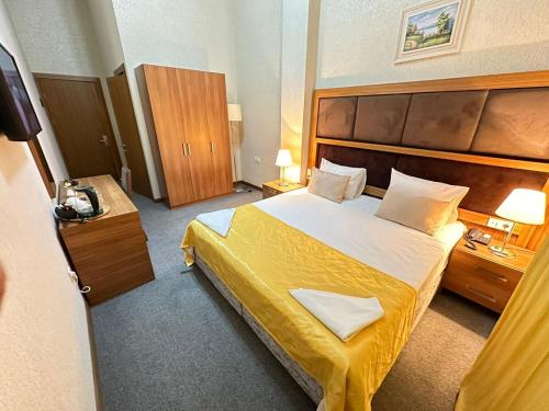 a hotel room with a large bed with yellow sheets at Turkiye Hotel - Free Massage in Baku