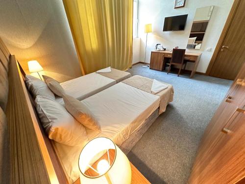 a hotel room with a bed and a desk at Turkiye Hotel - Free Massage in Baku