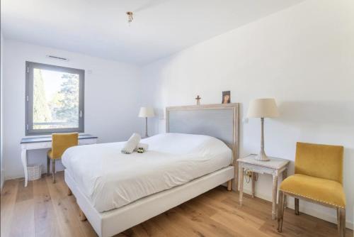 - une chambre blanche avec un lit et deux chaises dans l'établissement 3RAMT4 Superbe T4, Terrasse et Rooftop - vue sur mer, à Marseille