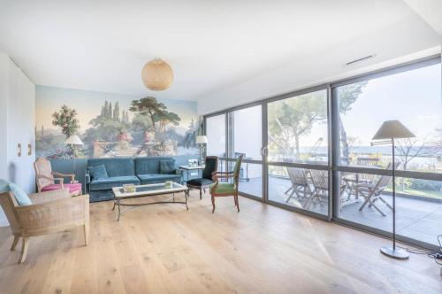 un salon avec un canapé bleu et des chaises dans l'établissement 3RAMT4 Superbe T4, Terrasse et Rooftop - vue sur mer, à Marseille