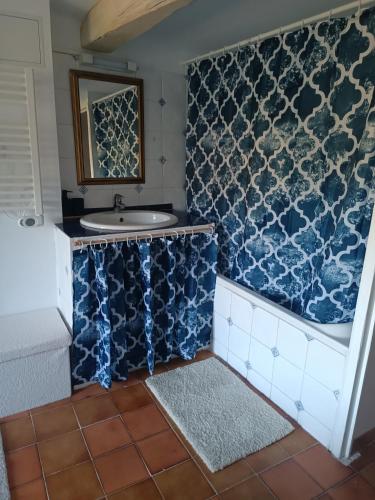 La salle de bains est pourvue d'un lavabo et de carrelage bleu et blanc. dans l'établissement Au puits de Figa, à Figanières