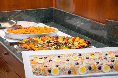 a buffet with plates of food on a table at Hotel Mondolé - Azzurro Club in Prato Nevoso
