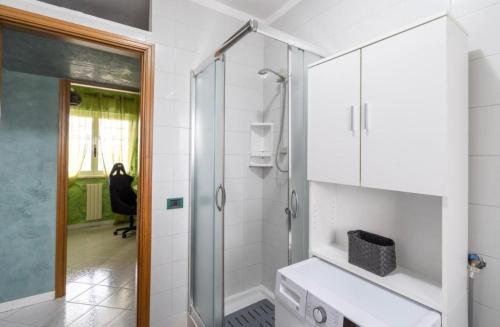 a white bathroom with a shower and a sink at Green House in Monopoli