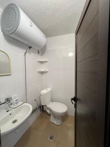 a bathroom with a white toilet and a sink at Чемерникъ in Gabrovnitsa