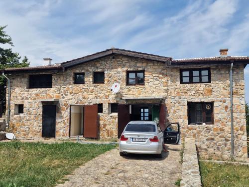 a car parked in front of a stone house at Чемерникъ in Gabrovnitsa