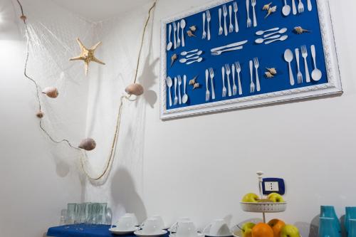 a blue sign on a wall next to a table with fruit at ControVento Rooms in Margherita di Savoia