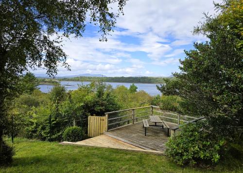 a bench on a deck with a view of a lake at Ard Veich Estate - Panoramic Highland Sea Views with private beach and woodland in Port Appin