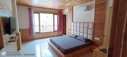 a bedroom with a bed and a large window at HOTEL ROSHAN REGENCY By seraj heritage in Shamshi