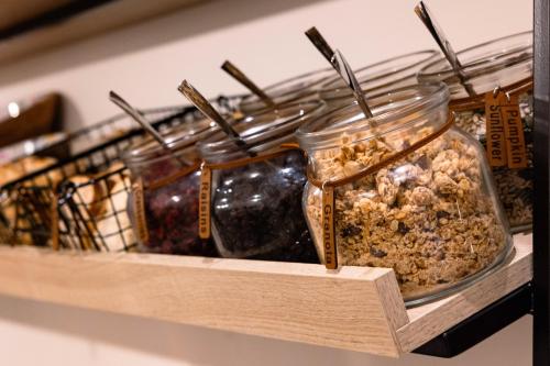 a row of jars of food on a shelf at Hotel Levante St Julian's, Affiliated by Melia in St Julian's