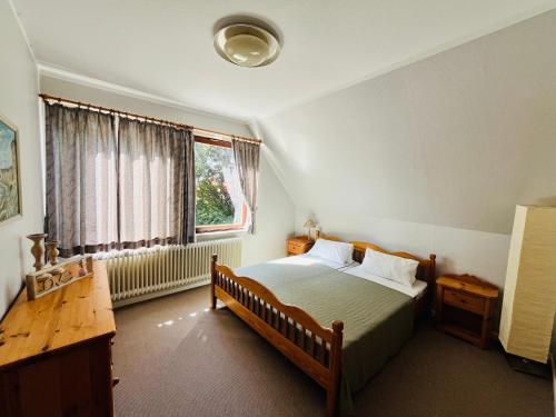 une chambre avec un lit, un bureau et une fenêtre dans l'établissement Süden, à Fehmarn