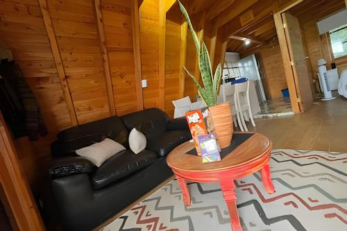 a living room with a black couch and a table at Cabaña Acogedora en finca de aguacates in Marinilla