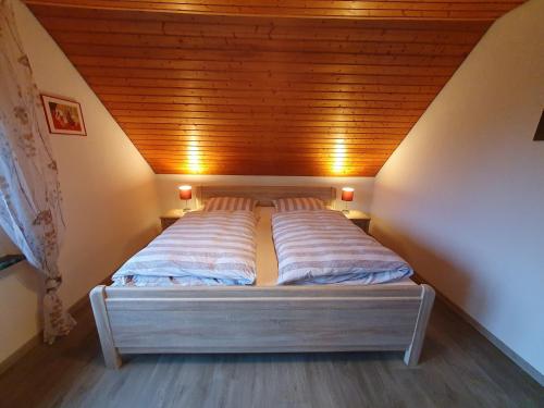 a bed in a room with a wooden ceiling at Ferienwohnung Luisa 35607 in Uplengen