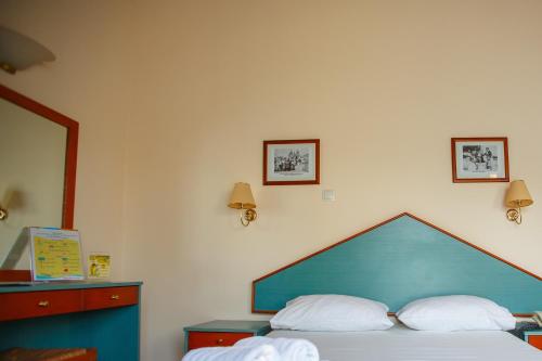 Filoxenia Apartments & Studios في ثيولوغيس: غرفة نوم مع سرير مع اللوح الأمامي الأزرق ووسادتين