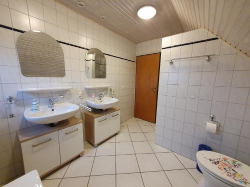 a bathroom with two sinks and a toilet at Ferienwohnung Luisa 35607 in Uplengen