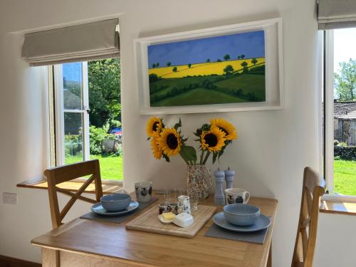 a dining room with a table with sunflowers on it at The Dale - Luxurious annexe with stunning view in Buckden