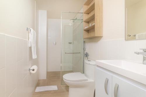 a white bathroom with a toilet and a sink at Radisson Riviera Panama in Punta Chame