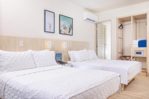 two beds in a hotel room with white sheets at Radisson Riviera Panama in Punta Chame