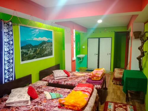 a room with two beds with colorful walls at Kabiraalaya Homestay in Darjeeling