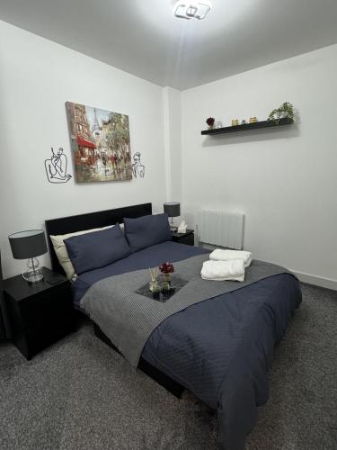 a bedroom with a large bed with blue sheets at 1 bed-Sleeps 4-Town Centre-10 min to Ascot- Pets in Bracknell
