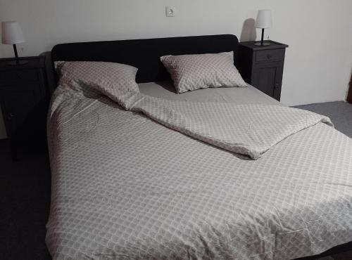 a large bed with a black headboard and two pillows at Holiday Home Vrata Bedemgrada in Našice