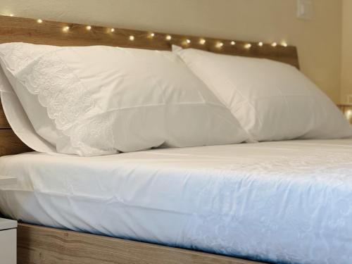 a bed with white pillows and lights on it at Casa di campagna 'Sa Vinzedda' in Galtellì