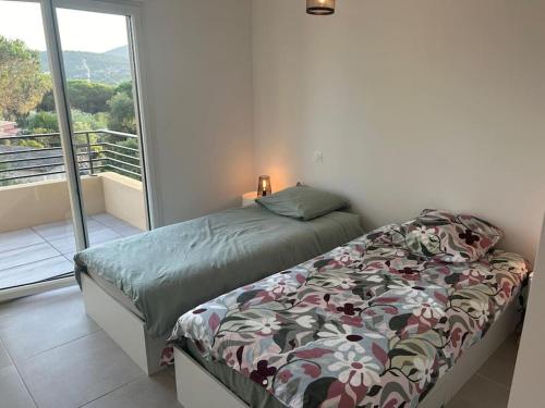 une chambre avec un lit et une grande fenêtre dans l'établissement villa 2 au Clos d Alice, à Sainte-Maxime