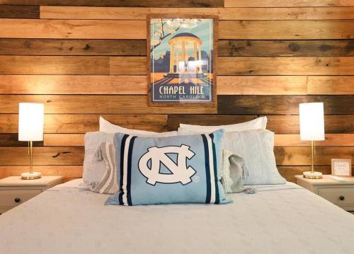 a bedroom with a bed with two lamps and a sign at Tiny Tarheel Cozy Retreat Near UNC Tiny House in Chapel Hill