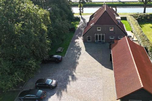 an overhead view of a house with two cars parked outside at B&B Aan de Vaart in Bovensmilde