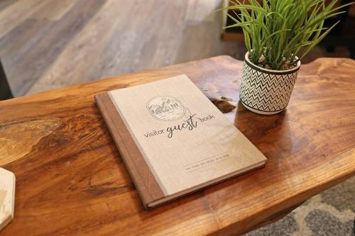 a book sitting on a wooden table with a potted plant at Tiny Tarheel Cozy Retreat Near UNC Tiny House in Chapel Hill