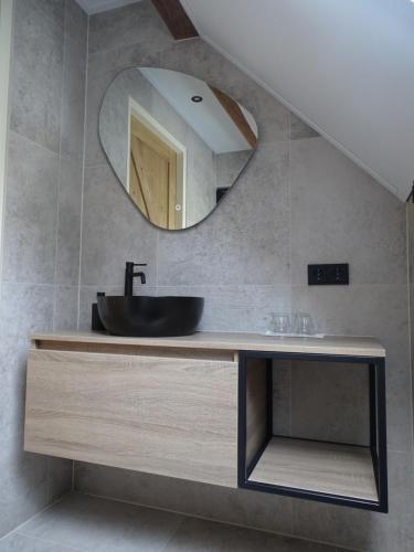 a bathroom with a sink and a mirror at B&B Aan de Vaart in Bovensmilde