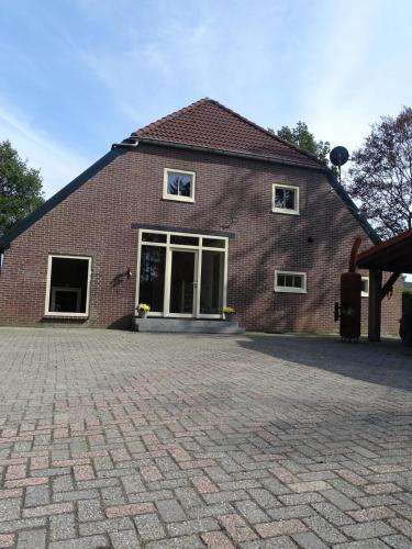 a brick building with a brick driveway in front of it at B&B Aan de Vaart in Bovensmilde