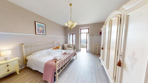 een grote slaapkamer met een bed en een kroonluchter bij Casale Massina APPARTAMENTO GIADA in Salò