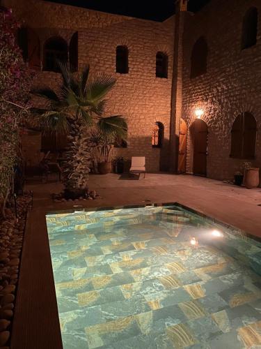 a large swimming pool in a courtyard at night at Villa lila in Essaouira