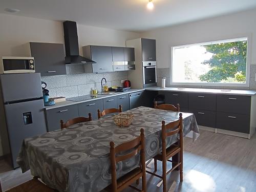 une cuisine avec une table et des chaises ainsi qu'une cuisine avec une fenêtre dans l'établissement Appart complet 2 chambres calme facture et repas possibles, à Beausemblant