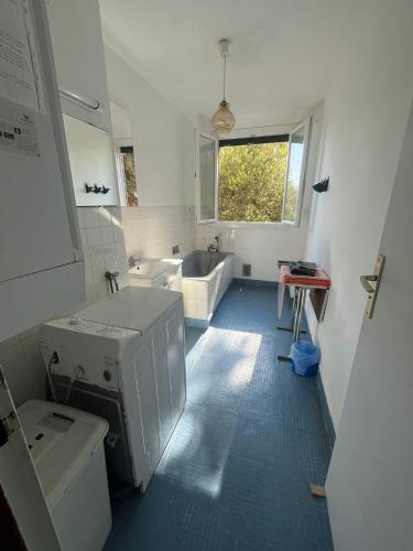 La salle de bains blanche est pourvue d'un lavabo et d'une baignoire. dans l'établissement Appartement vintage Bastia - MAGNIFIQUE VUE !, à Bastia