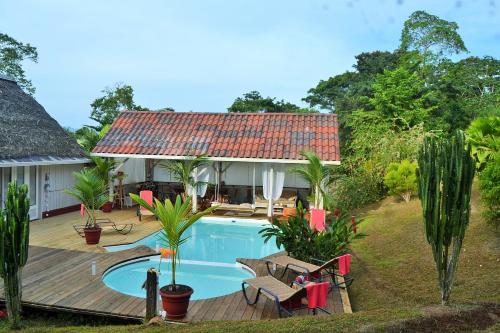 a villa with a swimming pool and a house at Nathylodge in Bocas del Toro