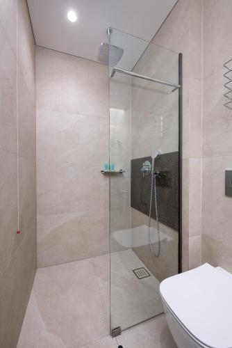 a bathroom with a glass shower with a toilet at Olympic Star Beach Hotel in Nei Poroi