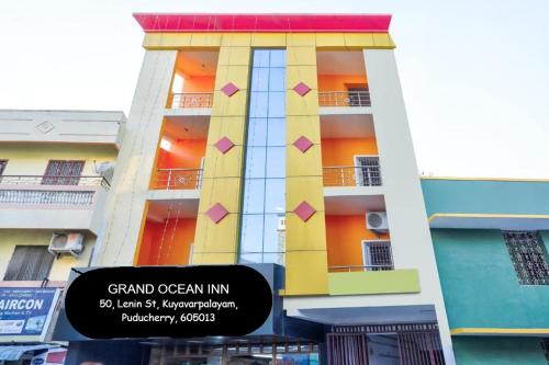un grand bâtiment avec une enseigne devant dans l'établissement Grand Ocean inn, à Pondichéry