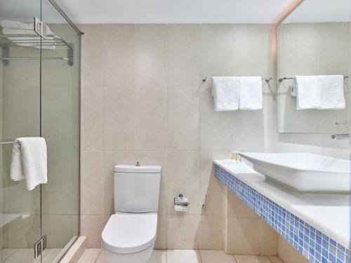 a bathroom with a toilet and a sink at Kinetta Beach Resort and Spa in Kineta