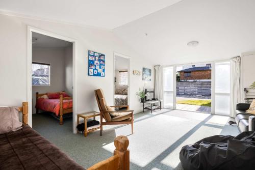 a living room with a bed and a couch at Beachfront Retreat in Mount Maunganui