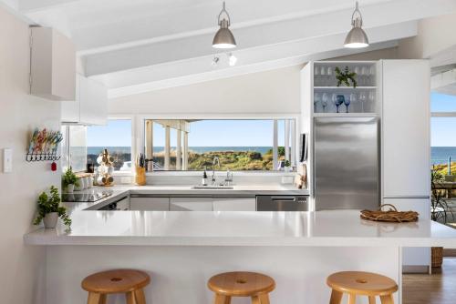 a kitchen with a view of the ocean at Beachfront Retreat in Mount Maunganui